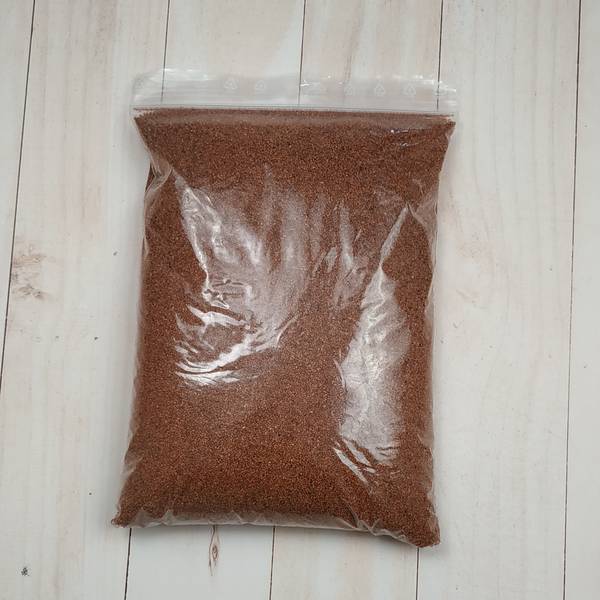 Brown decorative sand in a clear plastic bag, 0.4-0.8 mm grain size, 30 g pack, non-toxic and non-flammable.